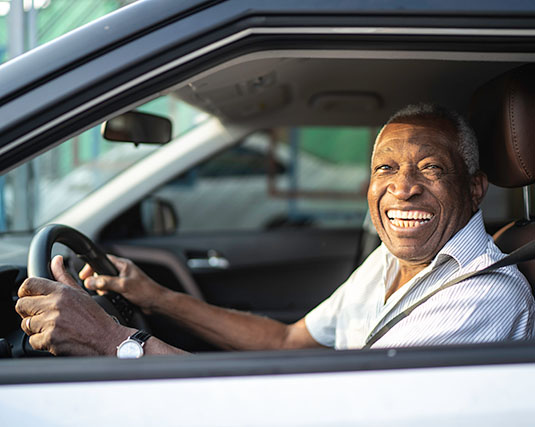 Man smiling driving a car