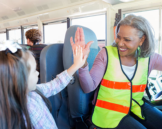Bus driver high-fiving a student