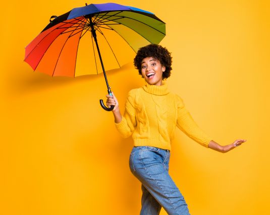 Happy woman holding a bright colored umbrella