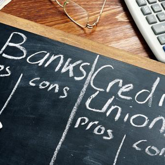 Chalkboard with pro and con columns for banks and credit unions
