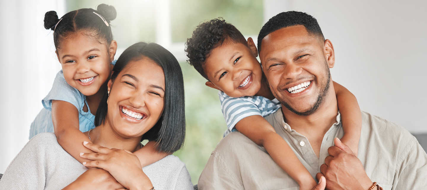 Happy black family, parents and children in a park in summer, smile and relax on grass field for love and fun in nature. Happiness, picnic and portrait of African people outdoor and playing together stock photo