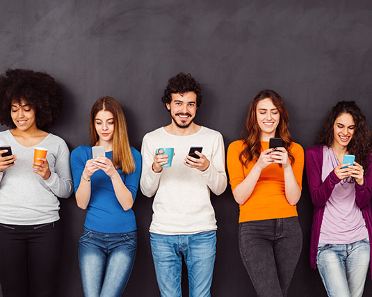 Group of young adults looking at their phones