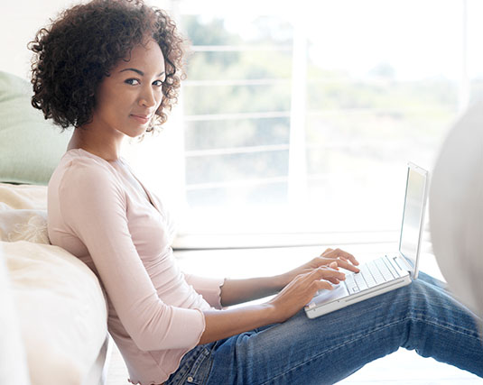 Woman sitting on the floor working on her laptop