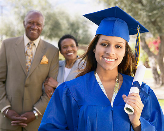 Graduate with parents in the background