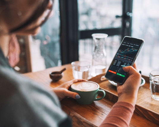 Woman investing in the stock market on her smartphone.